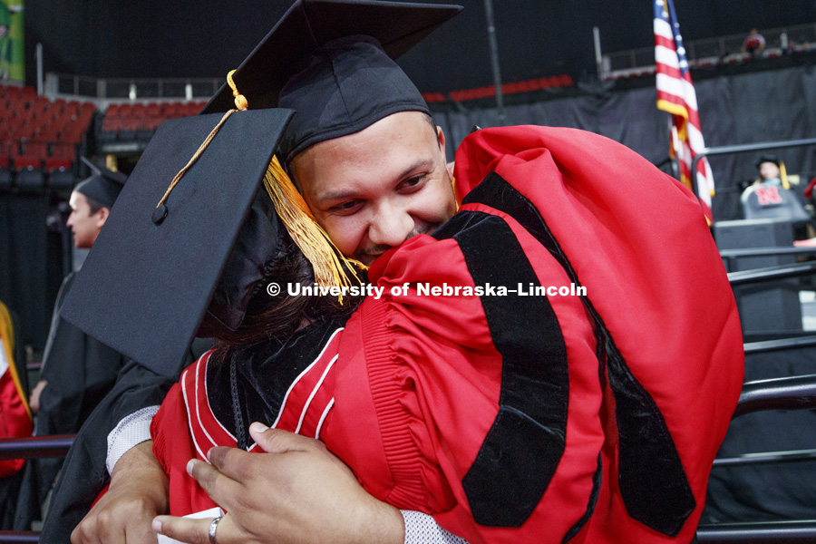 Clearthur Mangram gives assistant marshal Kara Brant a hug as he walks off stage. Summer Commencement at Pinnacle Bank Arena. August 11, 2018. Photo by Craig Chandler / University Communication.