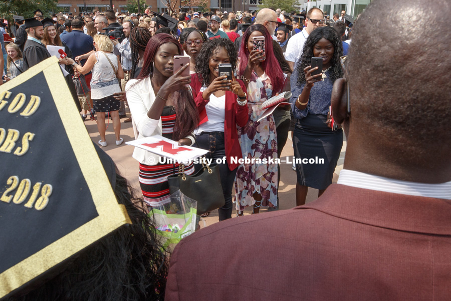 Nyanhial Tuom's family and friends take photos outside Summer Commencement at Pinnacle Bank Arena. August 11, 2018. Photo by Craig Chandler / University Communication.