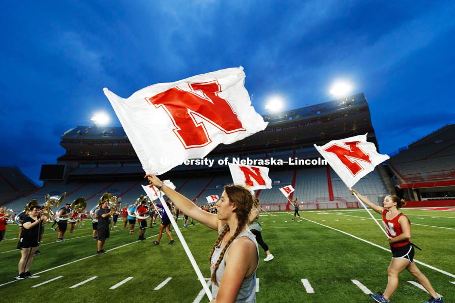 Flags ripple in the breeze as Amy Heusinkvelt and the Cornhusker Marching Band rehearse their pre-game routine. August 14, 2018. Photo by Craig Chandler / University Communication.