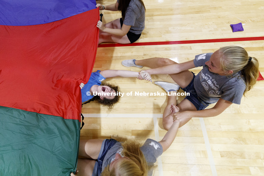 Hope Blomenberg laughs as she is rescued from being pulled under the parachute during a game of Chute Shark. She is in the pre-vet Learning Community. Learning Community Welcome Event in the rec center. August 17, 2018. Photo by Craig Chandler /
