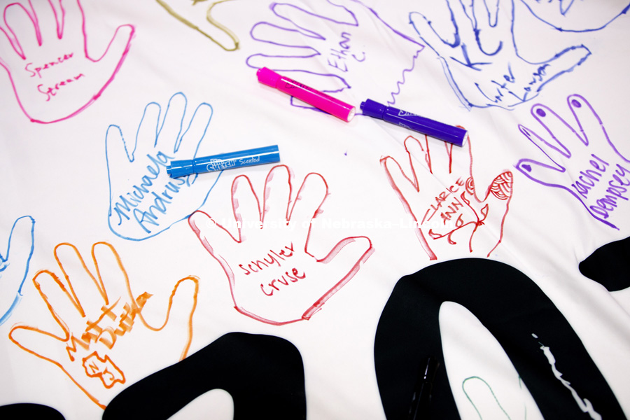 Learning Community members trace their hands on the Learning Community Banner. The banner will hang in Abel Sandoz Residence Center for the school year. Learning Community Welcome Event in the rec center. August 17, 2018. Photo by Craig Chandler /