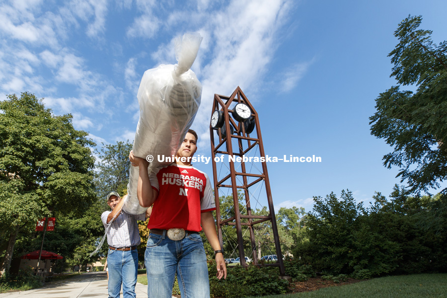 Colton Wiemer, a freshman in animal science from Blair, carries his carpet to his Massengale Residential Center room with the help of his dad, Kevin. Residence Hall move-in. August 16, 2018. Photo by Craig Chandler / University Communication.