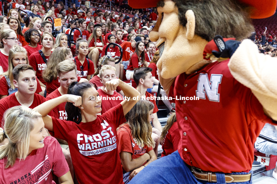 Abbey Schiemann compares muscles with Herbie Husker at the new student convocation at Bob Devaney Sports Center. August 17, 2018. Photo by Craig Chandler / University Communication.