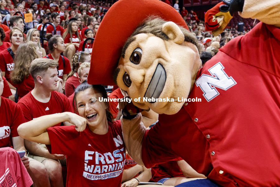 Abbey Schiemann compares muscles with Herbie Husker at the new student convocation at Bob Devaney Sports Center. August 17, 2018. Photo by Craig Chandler / University Communication.
