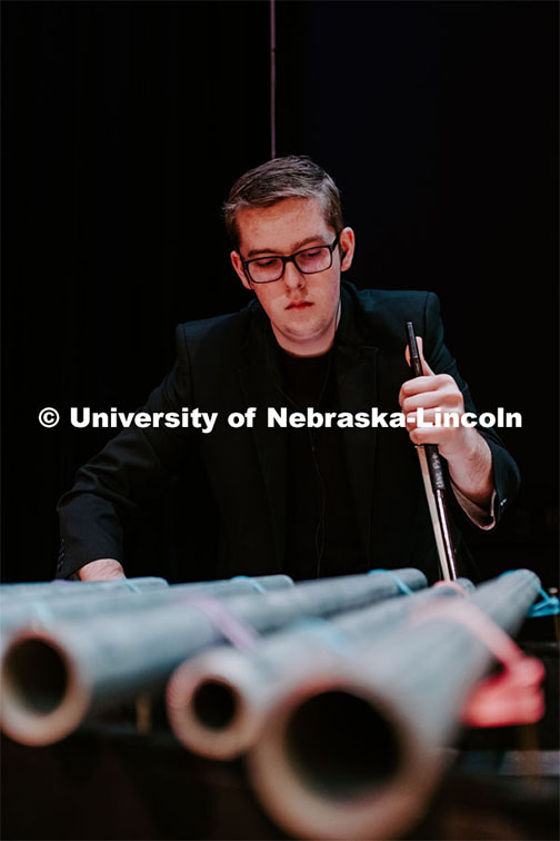 Andrew Wray using a bow on some metal pipes, Percussion Ensemble rehearsal. August 17, 2018. Photo by Justin Mohling / University Communication.