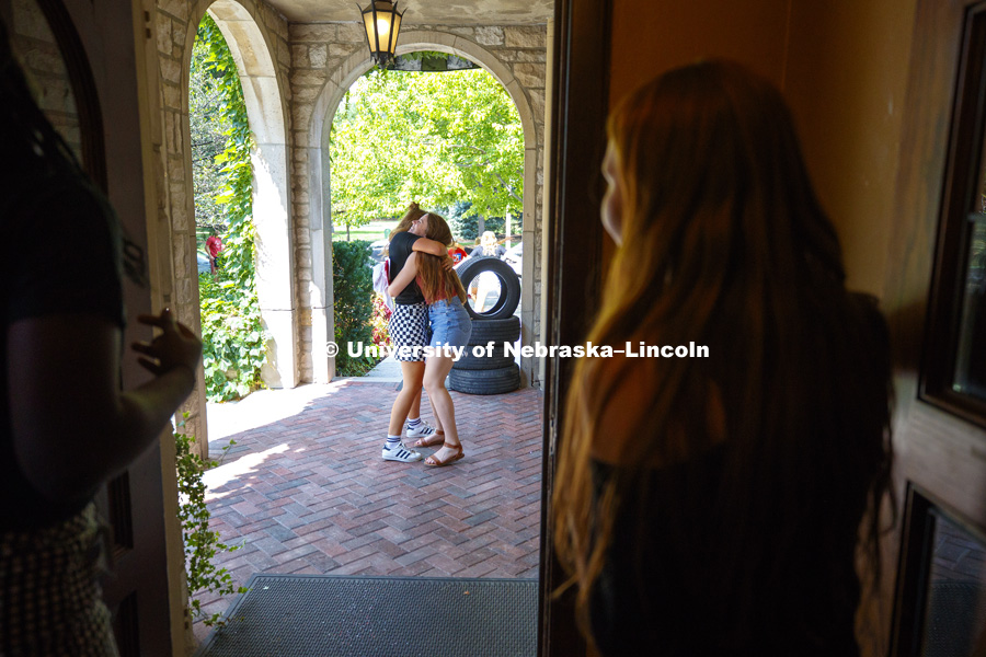 Hannah Cass is hugged on the porch of Alpha Xi Delta as she is greeted as part of new class. Bid Day for Greek Sororities. August 18, 2018. Photo by Craig Chandler / University Communication.