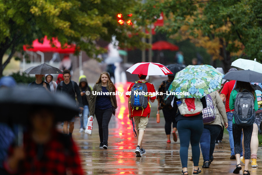 Students battle the rain as they cross campus to their first day of classes. August 20, 2018. Photo by Craig Chandler / University Communication