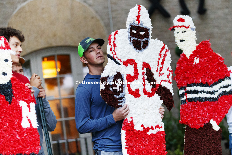 Cade Adamson of Alpha Gamma Rho holds a Johnny Rodgers cutout as Rodgers and other famous Huskers decorate the Chi Omega sorority lawn. Homecoming 2018 decorating yard displays. September 27, 2018. Photo by Craig Chandler / University Communication.