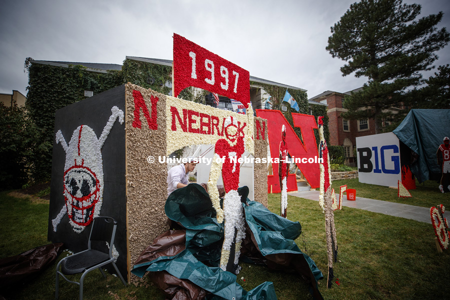 Drew Ash pulls off the protective tarp on half of the lawn display at Theta Xi. Homecoming 2018 decorating yard displays. September 27, 2018. Photo by Craig Chandler / University Communication.