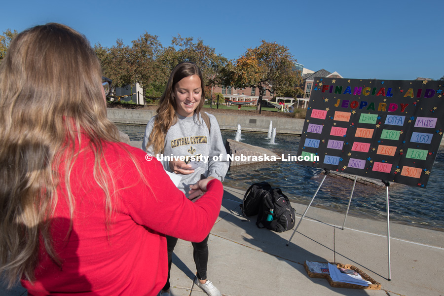 Tabitha Haynes, from the Scholarships and Financial Aid department plays Financial Aid Jeopardy with student, Tina Blaser outside the Nebraska Union on City Campus. October 17, 2018. Photo by Gregory Nathan, University Communication.