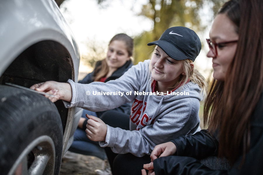 Samantha Emory of Norfolk, NE, photographs a scale on tire treads as part of collecting evidence. FORS 400 Crime Scene Investigation. Forensics class works at the site of an old house on the north side of east campus. October 22, 2018. Photo by Craig Chandler / University Communication.
