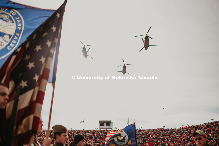 C-53 helicopters flyover with flags in foreground. Nebraska vs. Illinois football in Memorial Stadium. November 10, 2018. Photo by Justin Mohling / University Communication.