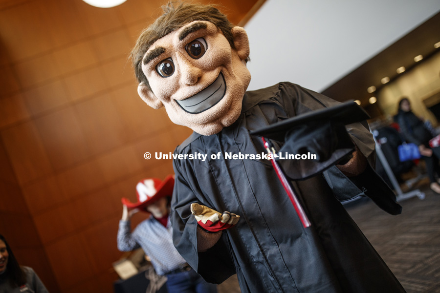 Herbie Husker being fitted for a graduation gown. November 29, 2018. Photo by Craig Chandler / University Communication.