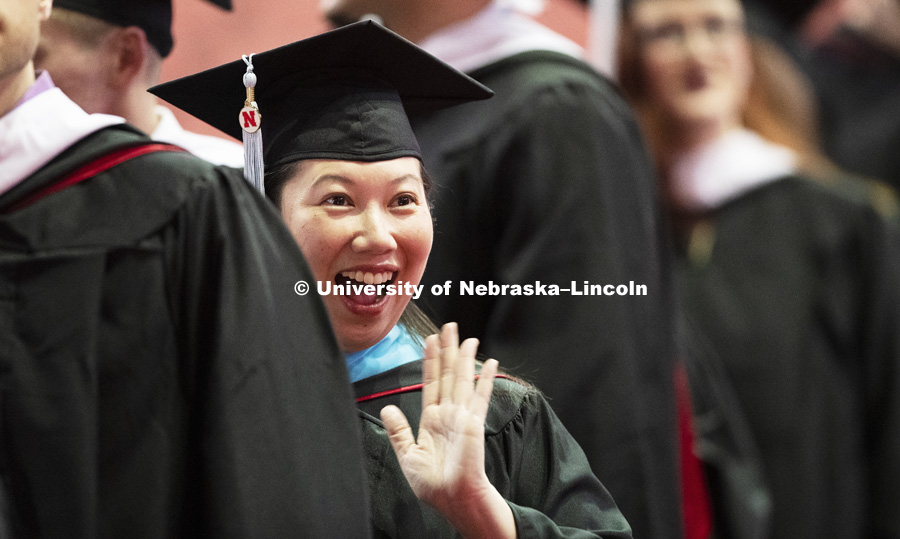 Graduates wave to family and friends as they enter the arena for the Graduate Commencement and Hooding. December 14, 2018. Photo by Craig Chandler / University Communication.