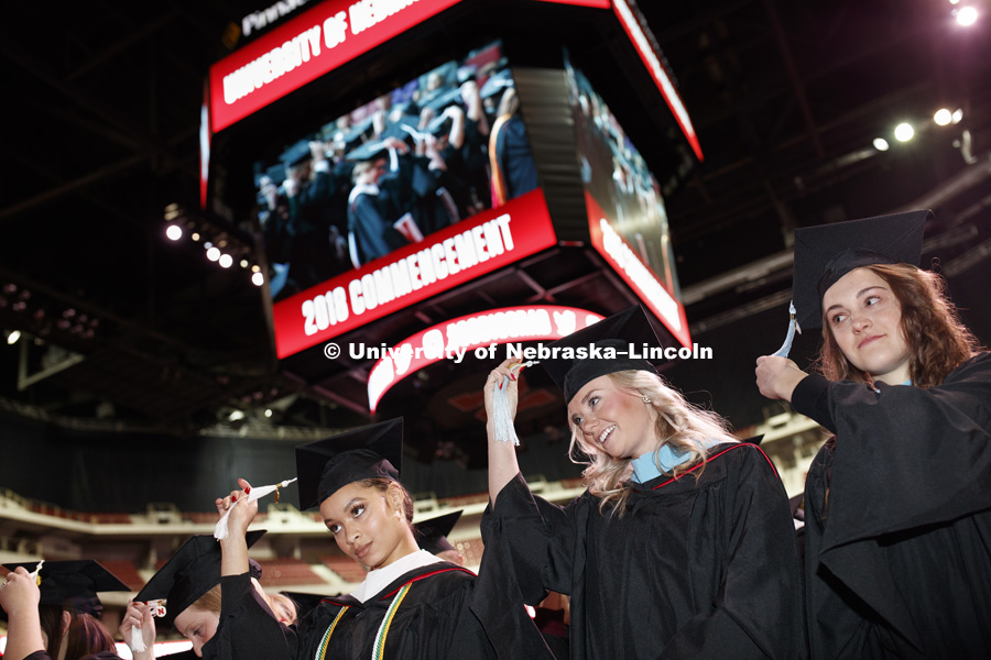 Virginia Hill, Masters in Political Science, Hillary Hotz, Masters in Educational Administration, and Melissa LaRosa, Masters in Educational Psychology, move their tassels over at the end of the Graduate Commencement and Hooding ceremony in Pinnacle Bank Arena. December 14, 2018. Photo by Craig Chandler / University Communication.