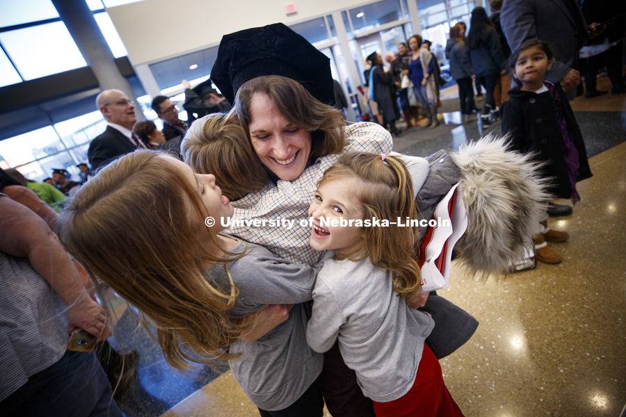 Janel Simons hugs her son, Henri, and nieces Lily and Juliana Petersen after she received her doctoral in English degree during the Graduate Commencement and Hooding ceremony in Pinnacle Bank Arena. December 14, 2018. Photo by Craig Chandler / University Communication.