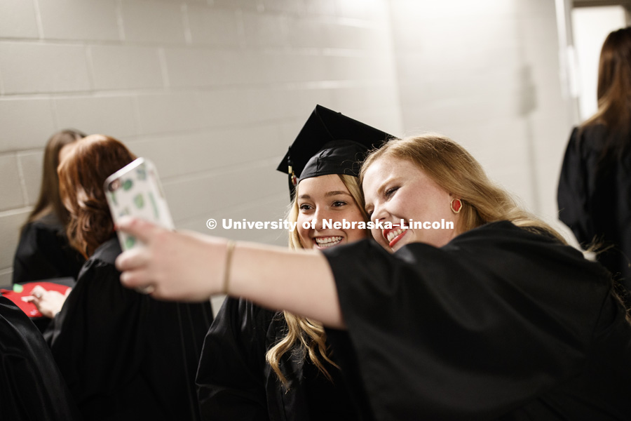 Katelynn Charroin and Rachel Cassidy take a selfie before the Undergraduate Commencement in Pinnacle Bank Arena. December 15, 2018. Photo by Craig Chandler / University Communication.