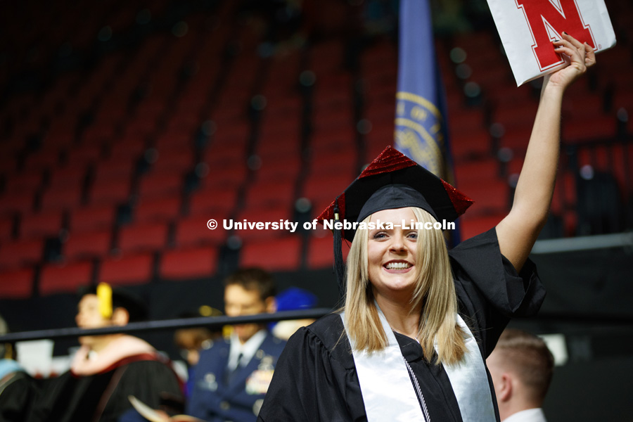 Michelle Henry shows off her diploma for family and friends after walking across stage at the Undergraduate Commencement in Pinnacle Bank Arena. December 15, 2018. Photo by Craig Chandler / University Communication.