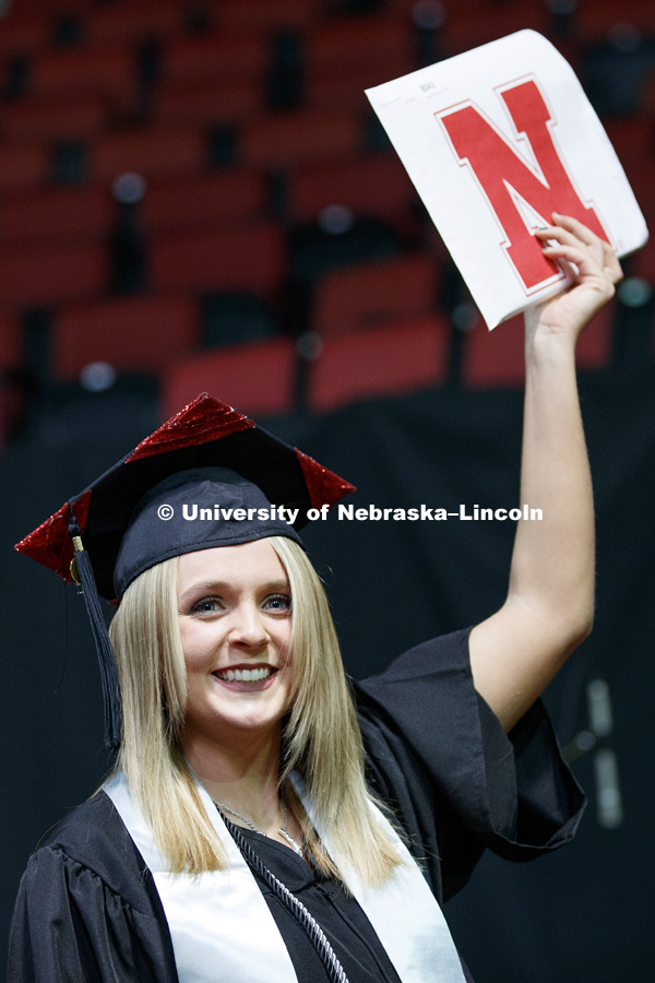 Michelle Henry shows off her diploma for family and friends after walking across stage at the Undergraduate Commencement in Pinnacle Bank Arena. December 15, 2018. Photo by Craig Chandler / University Communication.