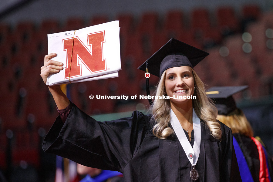 Sierra Nelson shows off her diploma for family and friends after walking across stage at the Undergraduate Commencement in Pinnacle Bank Arena. December 15, 2018. Photo by Craig Chandler / University Communication.