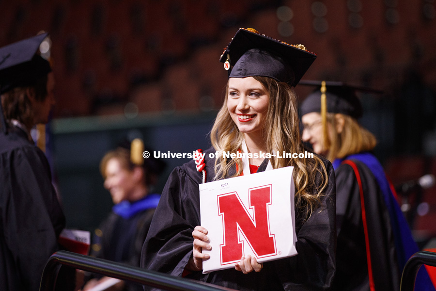 Shelby Riggs shows off her diploma for family and friends after walking across stage at the Undergraduate Commencement in Pinnacle Bank Arena. December 15, 2018. Photo by Craig Chandler / University Communication.