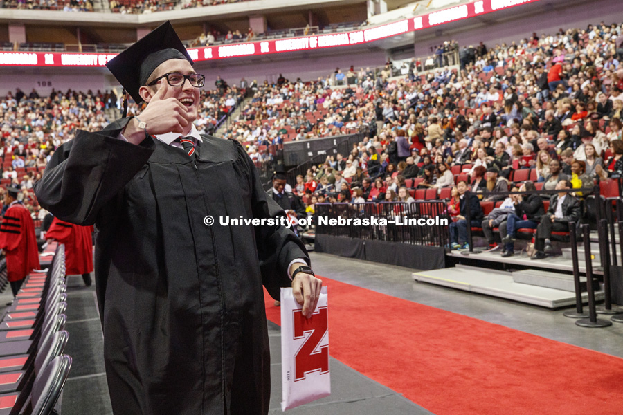 John Coufal poses for a photo as he returns to his seat after receiving his engineering degree. Undergraduate Commencement in Pinnacle Bank Arena. December 15, 2018. Photo by Craig Chandler / University Communication.