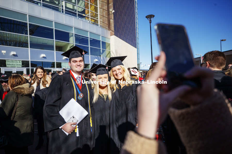 Ross Rogers, Paxton Norvell and Laine Swift pose for a photo outside Pinnacle Bank Arena after commencement. December 15, 2018. Photo by Craig Chandler / University Communication.