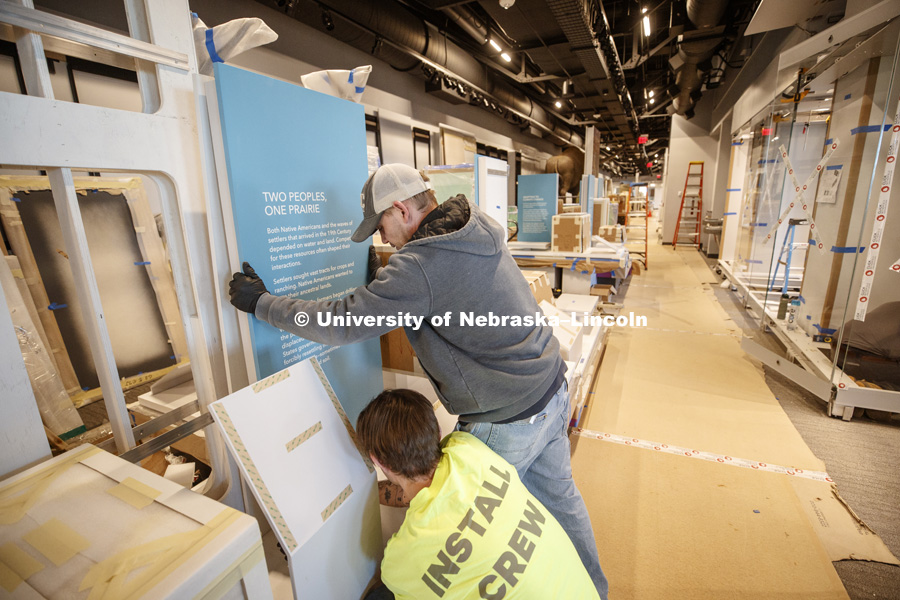 Steve Woodward of Pacific Studio holds a display board in place as it's attached to its stand. Cherish Nebraska exhibit at Morrill Hall's newly remodeled fourth floor. January 23, 2019. Photo by Craig Chandler / University Communication.
