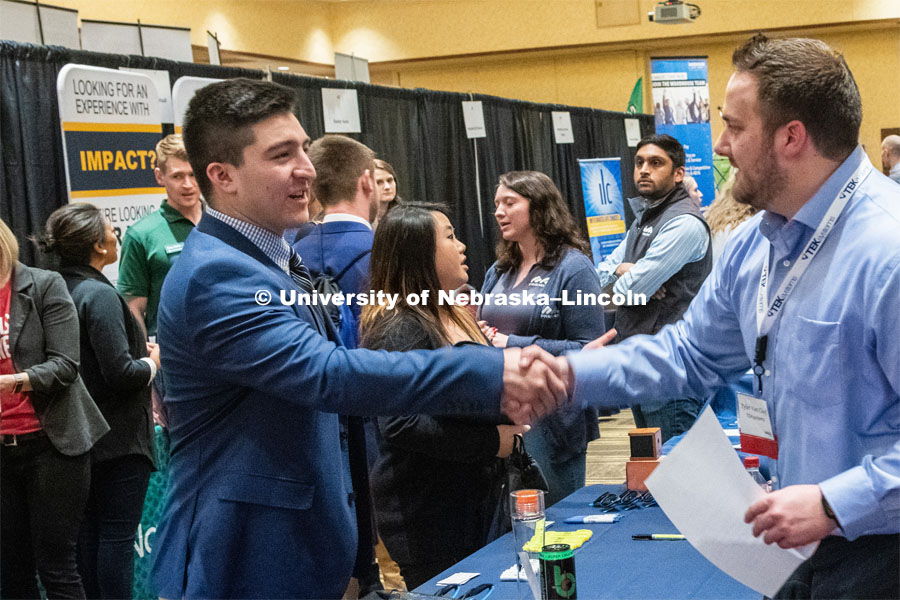Oscar Chavez-Franco introduces himself with a recruiter from TEK systems at the STEM Career Fair (Science, Technology, Engineering, and Math) in Embassy Suites. Sponsored by Career Services. February 12, 2019. Photo by Gregory Nathan / University Communication.