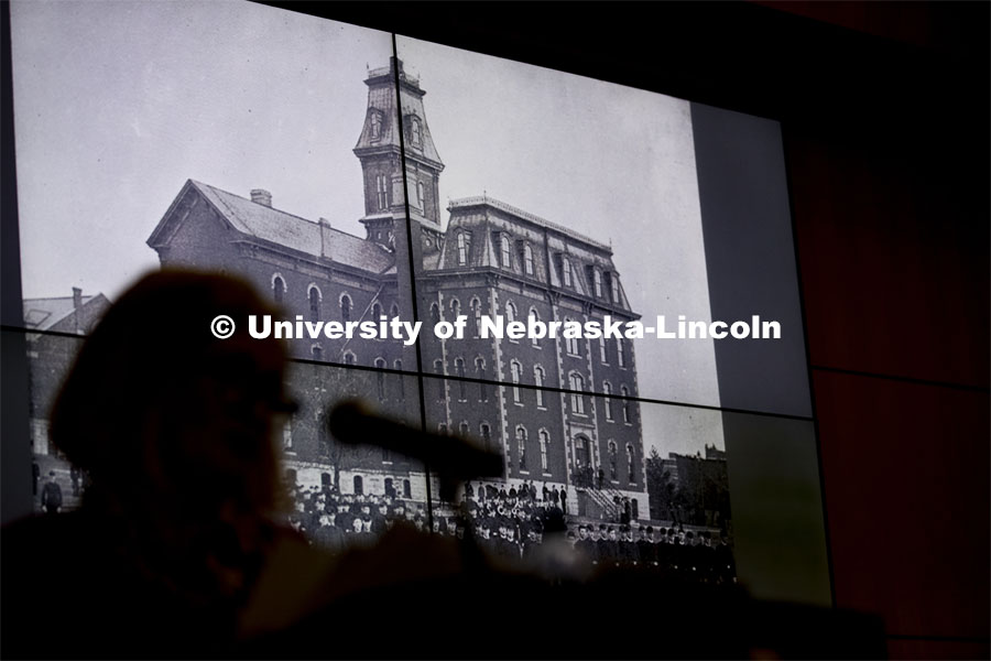 Kay Logan Peters is silhouetted by a photo of University Hall as she gives a special Nebraska Lecture as part of Charter Week on the University's early architectural history before a crowd of more than 300 people. February 12, 2019. Photo by Craig Chandler/University Communication.