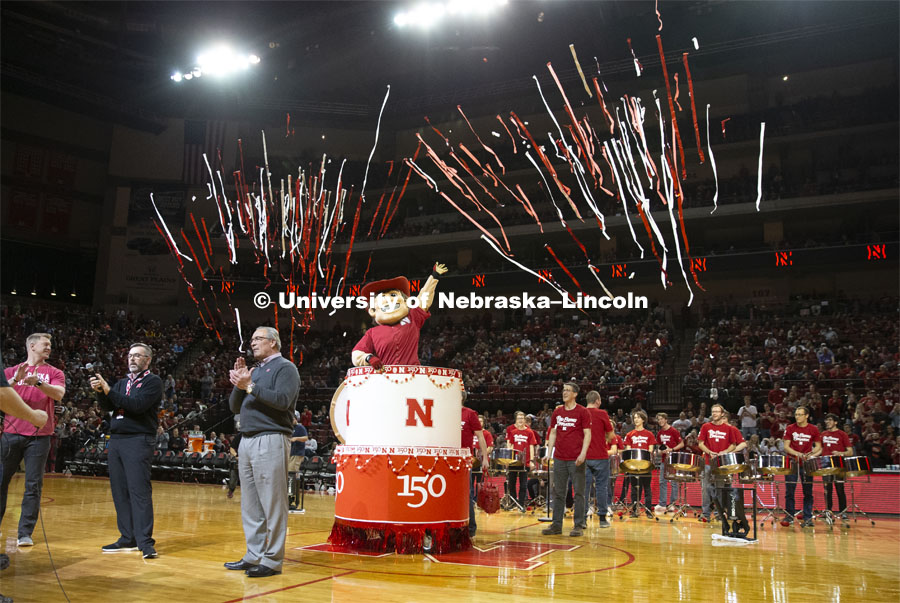 Herbie Husker pops out of a birthday cake as he and head football coach Scott Frost, Chancellor Ronnie Green and Athletic Director Bill Moos help celebrate the university's 150th birthday at the halftime show during the Huskers men’s basketball game. The Huskers played against Minnesota. February 13, 2019. Photo by Isabel Thalken / Husker Athletics.