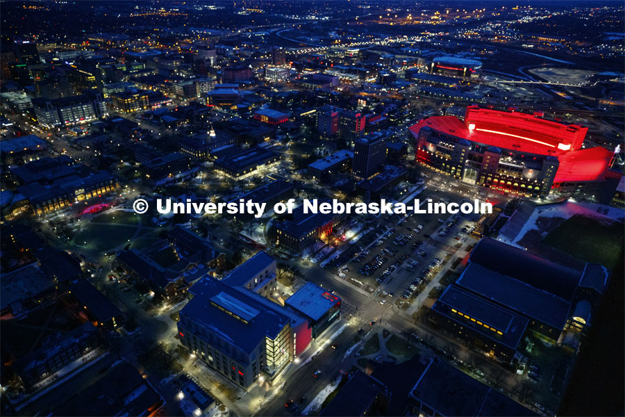 Memorial Stadium is a big red anchor to the colorful city campus Thursday night. At lower left is the College of Business. Center left is the Nebraska Union. Glow Big Red bathes the campuses with red lights as part of N150's Charter Week celebration. February 14, 2019. Photo by Craig Chandler / University Communication.