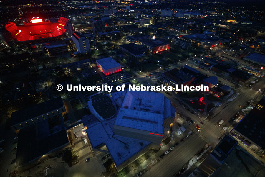 Memorial Stadium is a big red anchor to the colorful city campus Thursday night. At lower left is the Lied Center. Above the Lied is the Sheldon Art Museum and in the center is Love Library. Glow Big Red bathes the campuses with red lights as part of N150's Charter Week celebration. February 14, 2019. Photo by Craig Chandler / University Communication.