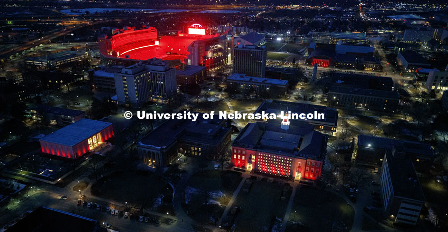 Clockwise from lower left is the Sheldon Art Museum, Memorial Stadium, the Coliseum and Love Library. Glow Big Red bathes the campuses with red lights as part of N150's Charter Week celebration. February 14, 2019. Photo by Craig Chandler / University Communication.