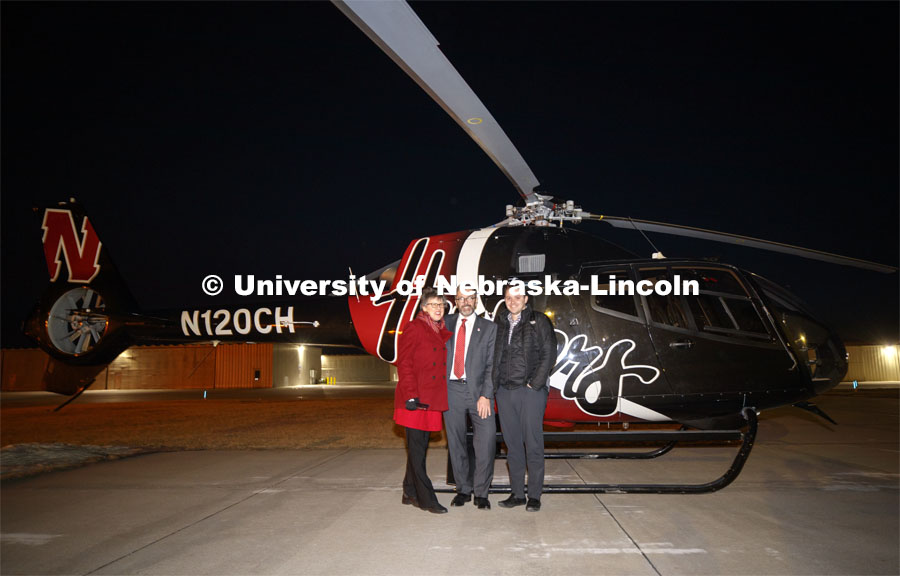 Chancellor Ronnie Green, his wife, Jane, and son, Nathan, prepare for a flight on the Husker Helicopter to get a birds-eye view of the red lights on campus as part of the Glow Big Red. Glow Big Red bathes the campuses with red lights as part of N150's Charter Week celebration. February 14, 2019. Photo by Craig Chandler / University Communication.
