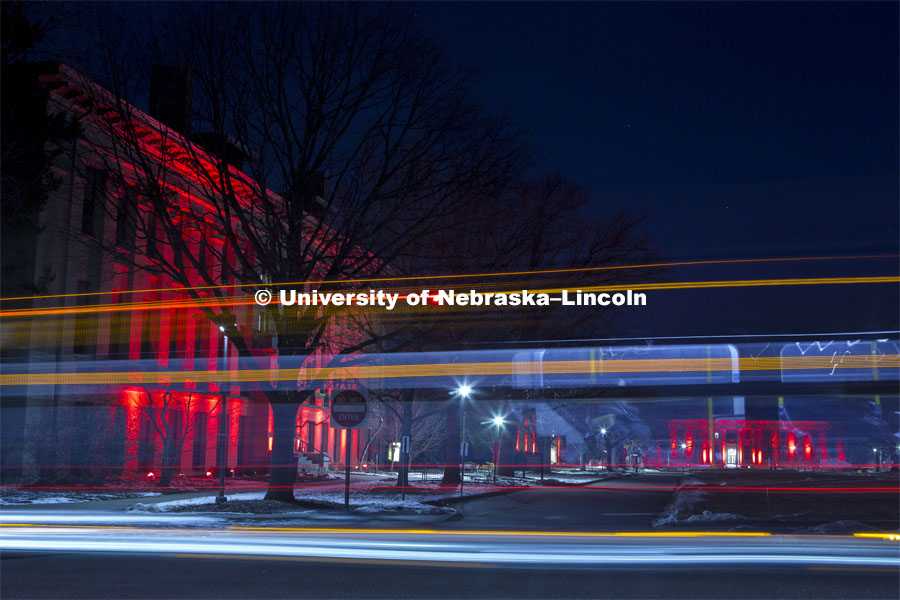 A bus drives by Agriculture Hall during Glow Big. Glow Big Red bathes the campuses with red lights as part of N150's Charter Week celebration. February 14, 2019. Photo by James Wooldridge for University Communication.