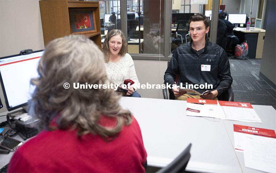 Anna Plank, assistant director of Husker Hub, talks with student Ben Houck and his mother, Cheryl, in the temporary home for Husker Hub. The new one-stop shop offers integrated services, including the offices of Scholarships and Financial Aid, University Registrar, Bursar, and Student Accounts. The hub opened in Pound Hall and will move into a permanent space in Canfield Administration Building. March 8, 2019. Photo by Craig Chandler / University Communication.