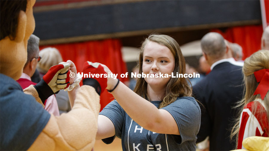 Kelsey Schlichtman fist bumps Herbie Husker as she runs through a tunnel walk of high-fives at the FFA signing ceremony for current senior FFA members who have committed to Nebraska. April 3, 2019. Photo by Craig Chandler / University Communication.