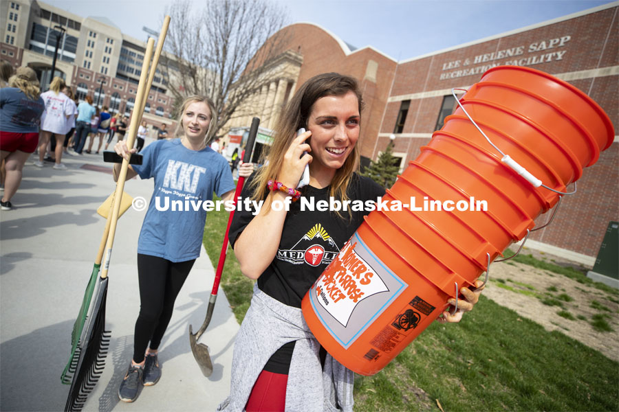 Brooklyn Housh calls her team as she and Kennedy Wolfe carry supplies from the Coliseum. More than 2,500 University of Nebraska–Lincoln students, faculty and staff volunteered for the Big Event on April 6, completing service projects across the community. Now in its 13th year at Nebraska, the Big Event has grown to be the university's single largest student-run community service project. April 6, 2019. Photo by Craig Chandler / University Communication.