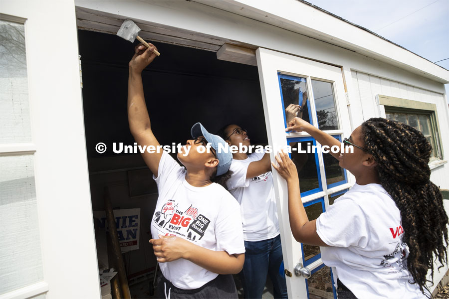 Nebraska's Iesha Bryant reaches for the top of the doorway as she and others in the Minority Pre-Health Association painted a shed and cleaned up a yard during the Big Event. More than 2,500 University of Nebraska–Lincoln students, faculty and staff volunteered for the Big Event on April 6, completing service projects across the community. Now in its 13th year at Nebraska, the Big Event has grown to be the university's single largest student-run community service project. April 6, 2019. Photo by Craig Chandler / University Communication.
