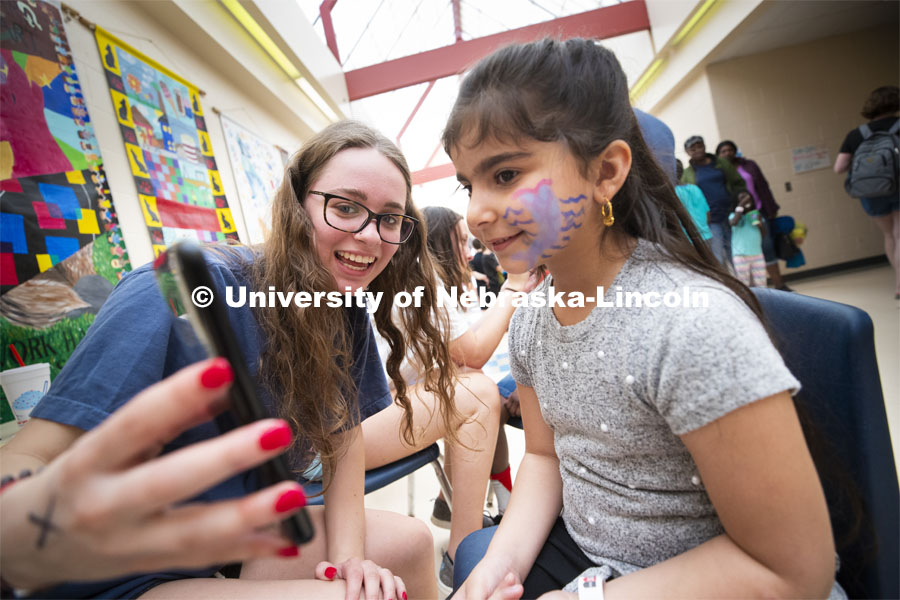 Nicole Boreyk shows her artwork to an elementary student at the face-painting table. She and others from Gamma Phi Beta helped with the Campbell Elementary School Carnival. More than 2,500 University of Nebraska–Lincoln students, faculty and staff volunteered for the Big Event on April 6, completing service projects across the community. Now in its 13th year at Nebraska, the Big Event has grown to be the university's single largest student-run community service project. April 6, 2019. Photo by Craig Chandler / University Communication.