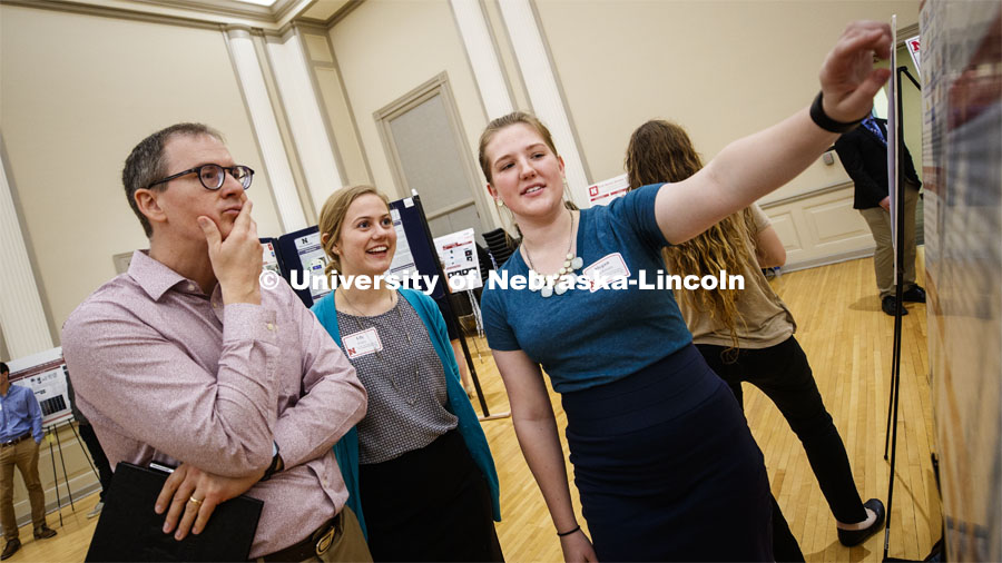 Gregory Bashford, left, and Lily Foley listen to Megan Ruckman present her poster. Undergraduate Spring Research Fair in the Union ballrooms. April 15, 2019. Photo by Craig Chandler / University Communication.