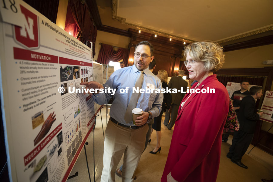 Chris Wiseman from Bellevue explains his poster to Senator Sue Crawford of the District 45. This year's research day at the capitol was held at the neighboring Ferguson House. Wiseman is researching “A wirelessly-controlled smart bandage with integrated miniaturized needle arrays for the treatment of chronic wounds.” State Senators Research Fair at the Ferguson House. April 16, 2019. Photo by Craig Chandler / University Communication.