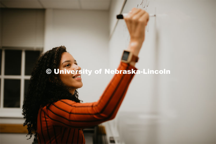 Grad student writing on a marker board in a Louis Pound Hall classroom. April 23, 2019. Photo by Justin Mohling / University Communication.
