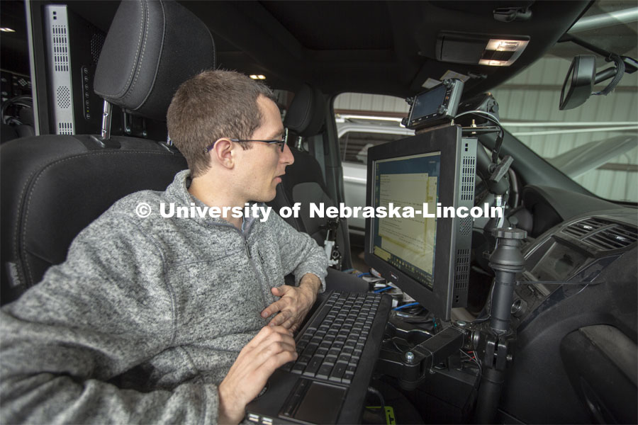 Graduate student Matt Wilson reviews code in programs that are used to collect real-time storm data. All data collected is stored in computers located in the back of Nebraska's mesonet vehicles. The data is backed up daily. April 26, 2019. Photo by Troy Fedderson / University Communication