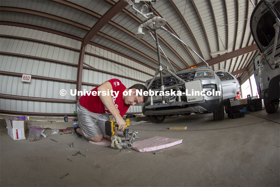 Graduate student Alex Erwin drills a pipe that will hold an instrument cluster on Nebraska's newest storm chase vehicle. Starting this spring, 13 Huskers will be part of TORUS, a national study designed to collect data about how severe storms and tornadoes are formed. April 26, 2019. Photo by Troy Fedderson / University Communication