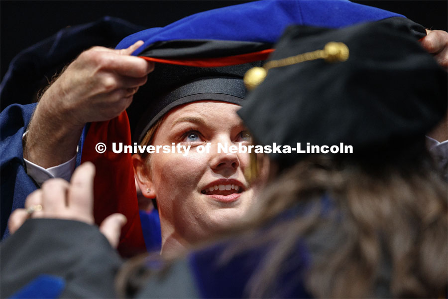 Jaclyn Marsh eyes her doctoral hood. 2019 Spring Graduate Commencement in Pinnacle Bank Arena. May 3, 2019. Photo by Craig Chandler / University Communication