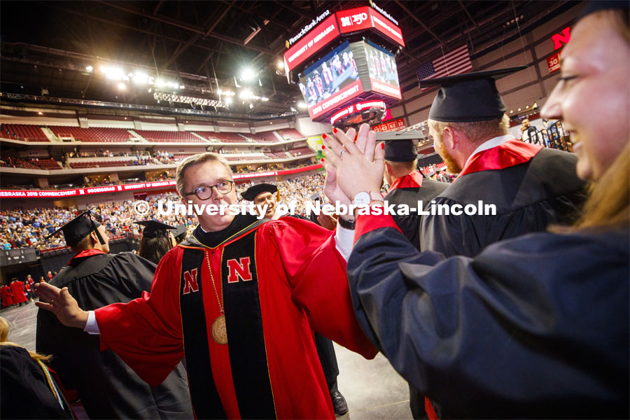 Chancellor Ronnie Green high fives graduates as they progress into the arena. Undergraduate commencement at Pinnacle Bank Arena, May 4, 2019. Photo by Craig Chandler / University Communication.