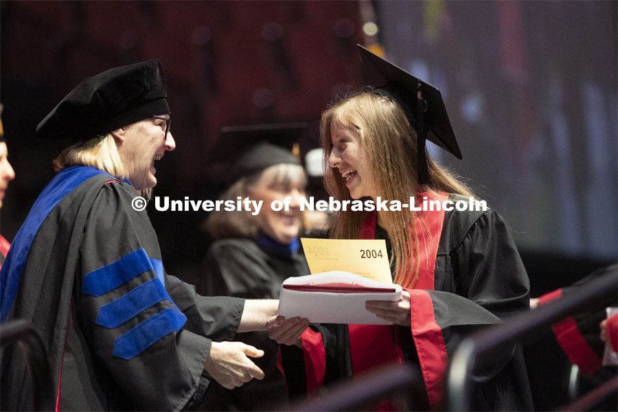 Lindsey Amen accepts her college of journalism diploma. Undergraduate commencement at Pinnacle Bank Arena, May 4, 2019. Photo by Craig Chandler / University Communication.