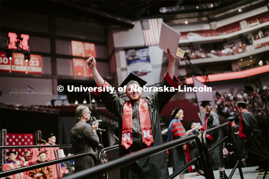 Jacob Andrews gestures to family and friends after receiving his College of Business diploma. Undergraduate commencement at Pinnacle Bank Arena, May 4, 2019. Photo by Craig Chandler / University Communication.